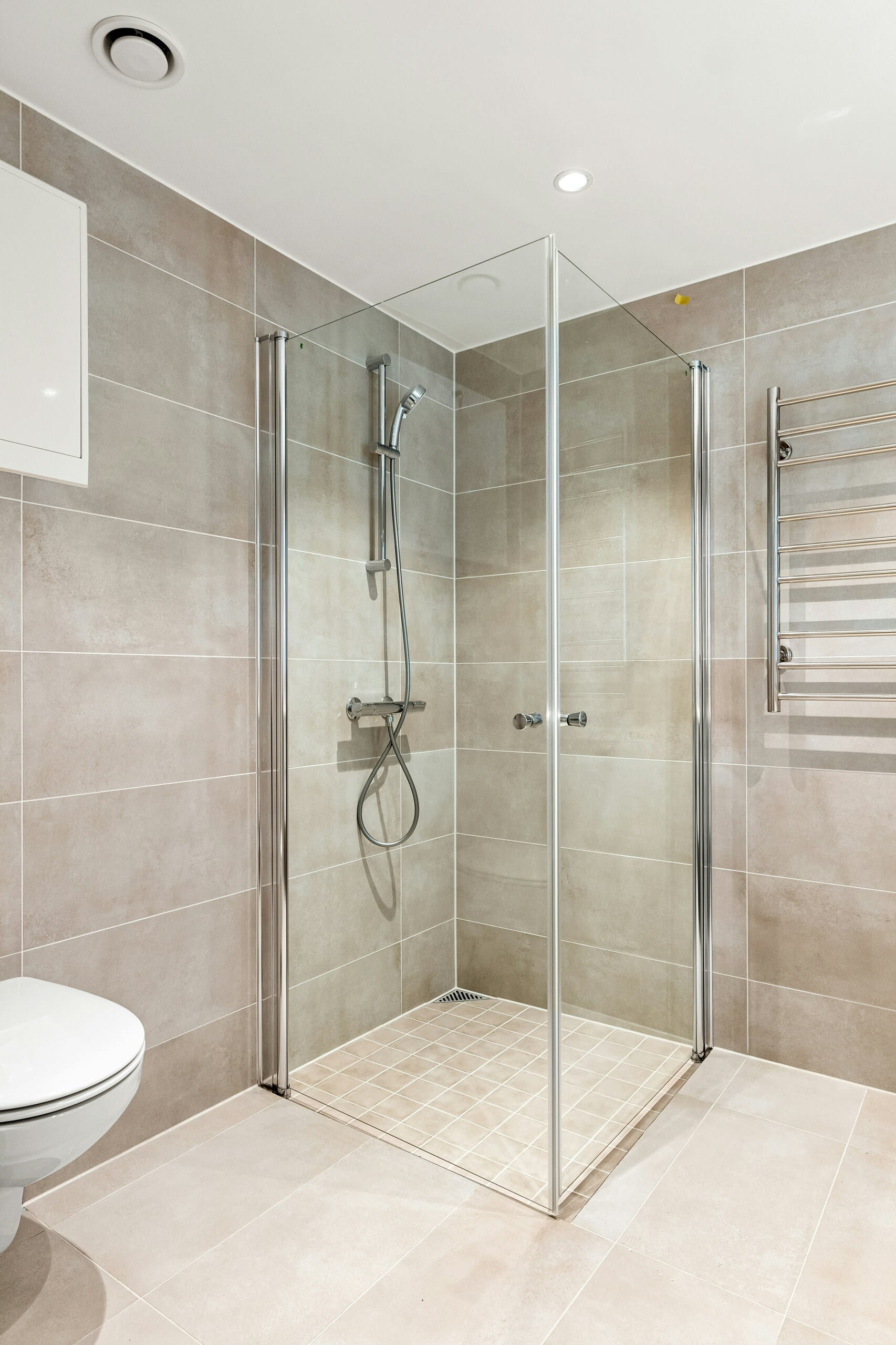 Frameless shower screen fitted against tiled walls in a Perth bathroom